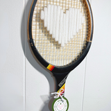 White heart-shaped racquet by What A Racquet! with a black frame, featuring a sleek design and comfortable grip.