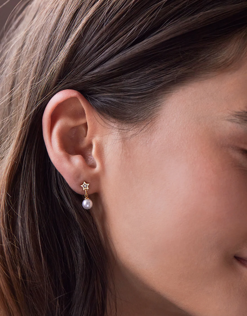 Estella Bartlett star and pearl stud earrings featuring small pearl accents and star-shaped designs on silver posts.