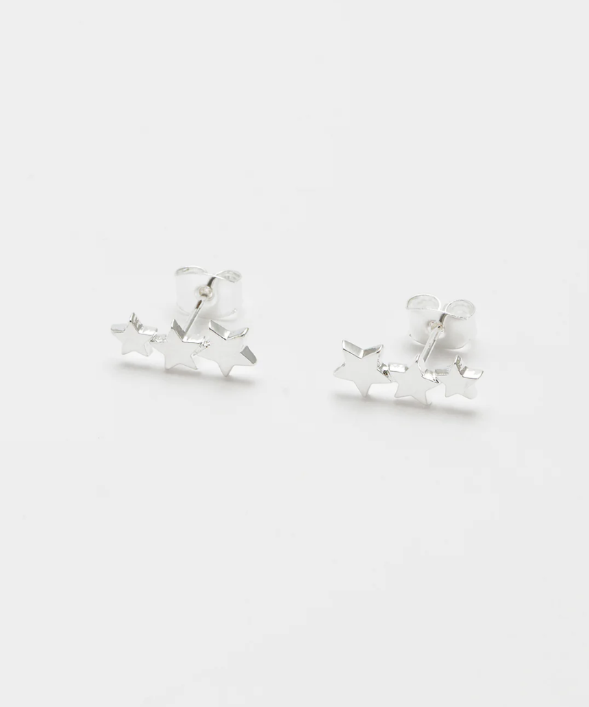 Estella Bartlett trio star stud earrings featuring three small star-shaped silver earrings on a white background.
