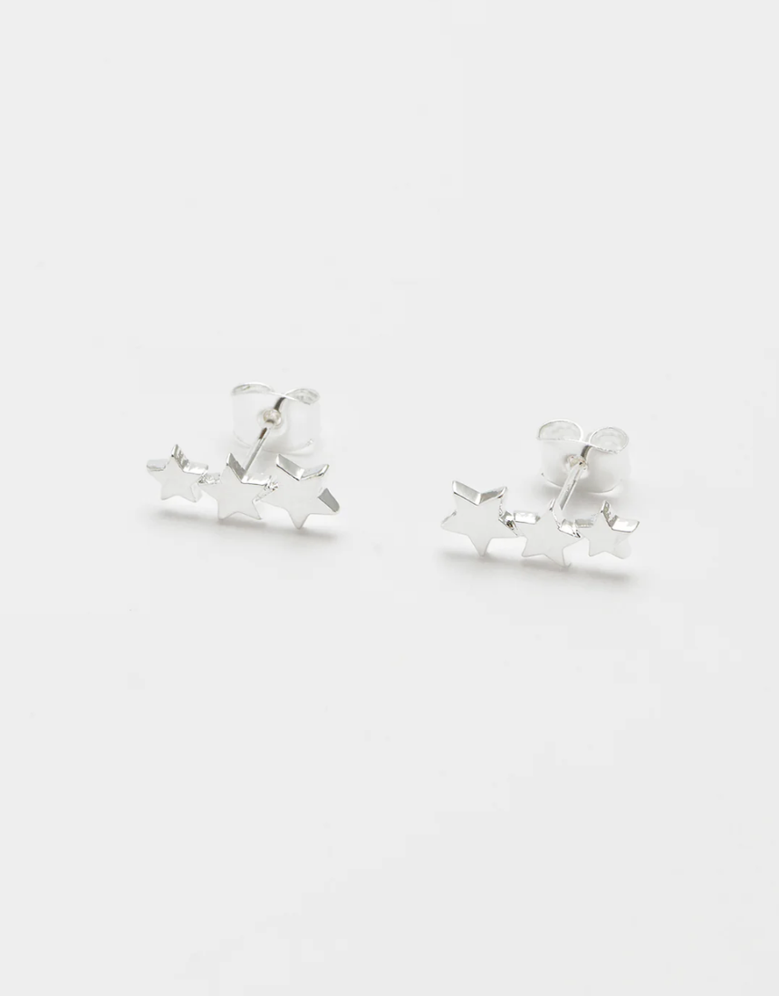 Estella Bartlett trio star stud earrings featuring three small star-shaped silver earrings on a white background.