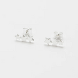 Estella Bartlett trio star stud earrings featuring three small star-shaped silver earrings on a white background.