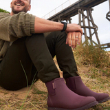 Dark cherry Merry People Bobbi gumboots with a glossy finish and sturdy soles, designed for waterproof outdoor wear.