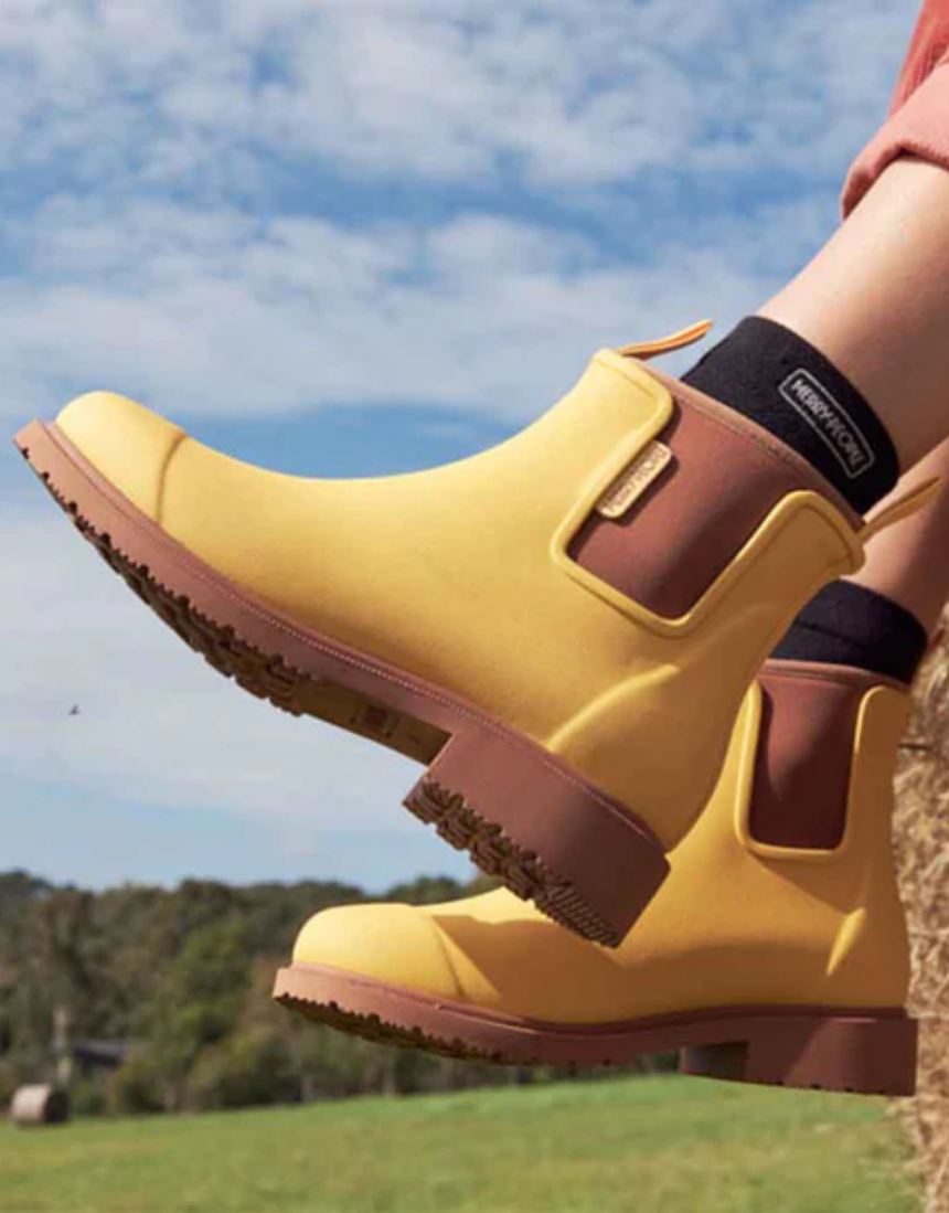 Yellow Merry People Bobbi gumboots with sunflower design, waterproof rain boots for women and outdoor wear.