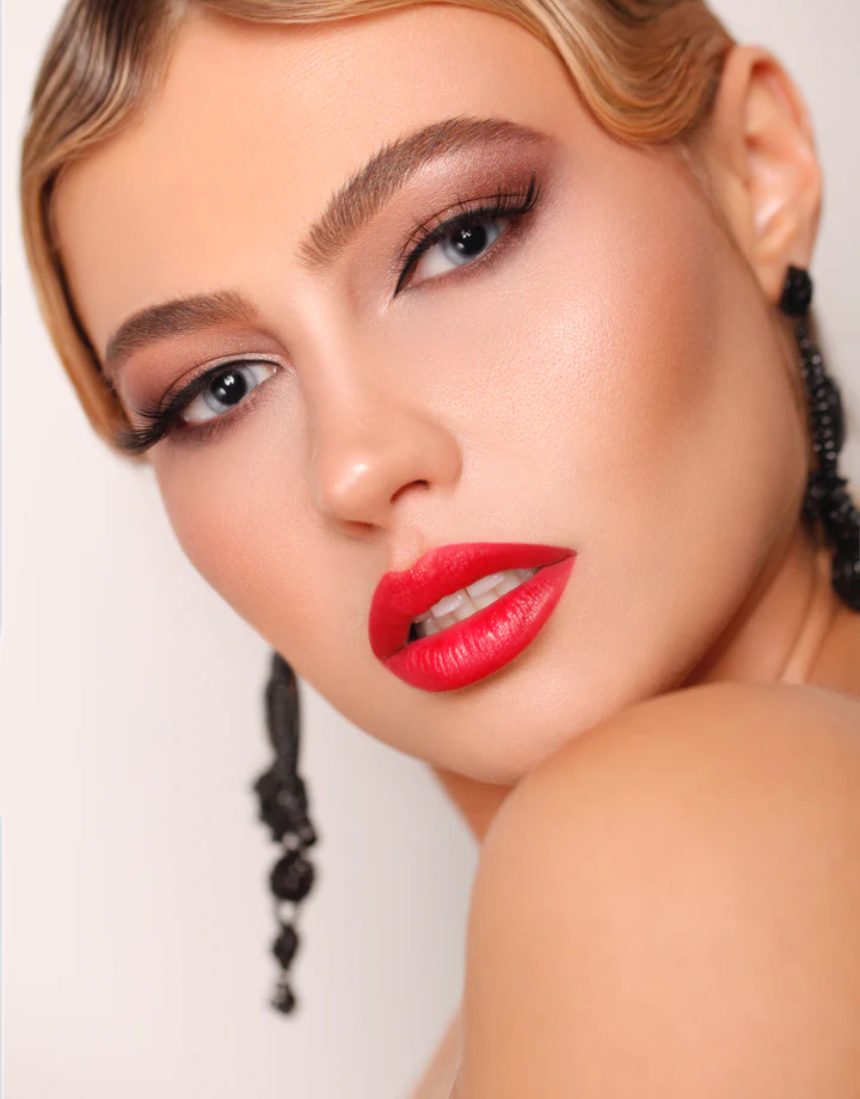 Suzy Lipsticks Poppy matte lipstick in sleek tube, vibrant coral-orange shade with a smooth, velvety finish.