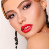 Suzy Lipsticks Poppy matte lipstick in sleek tube, vibrant coral-orange shade with a smooth, velvety finish.