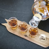 Set of Gentlemen's Hardware shot glasses with a serving paddle, featuring rustic wood and glass design for stylish serving.
