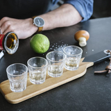 Gentlemen's Hardware shot glasses with a serving paddle, showcasing a rustic design and clear glass construction.