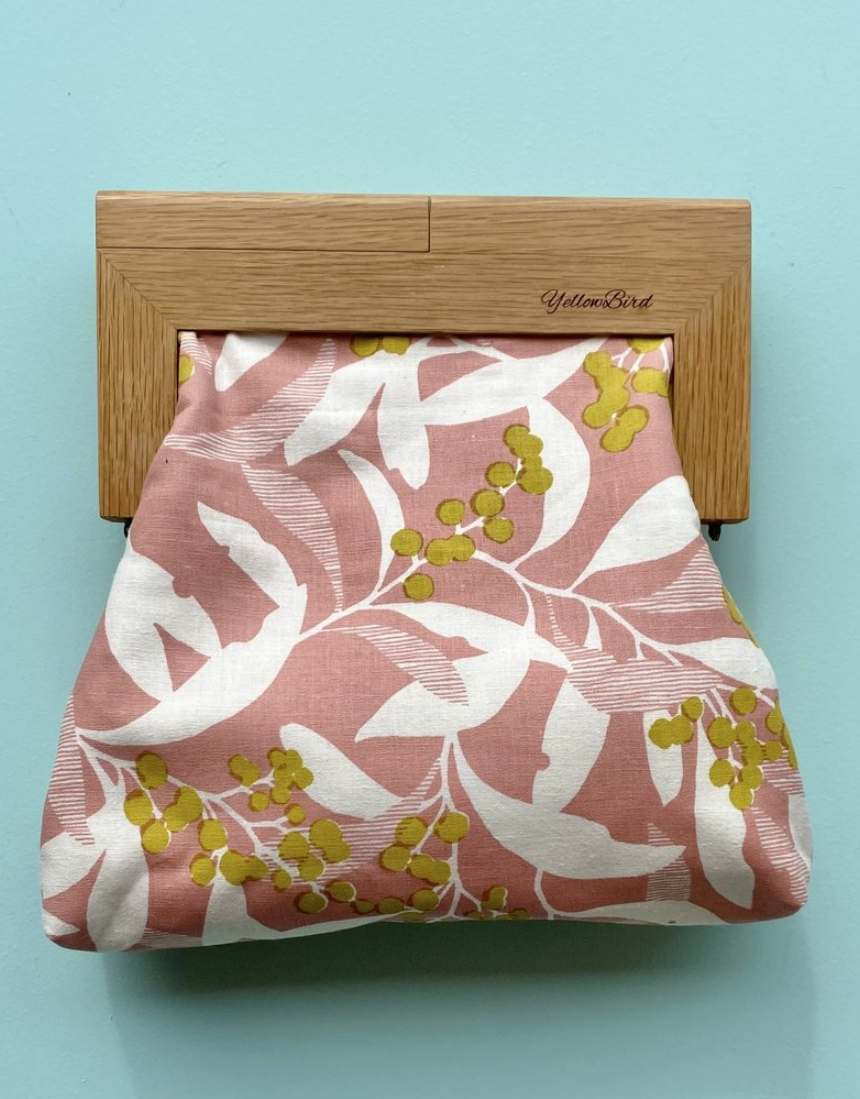 Yellow Bird Signature Medium Clutch with Wattle Tassie Oak frame, showcasing a sleek design and vibrant yellow color.